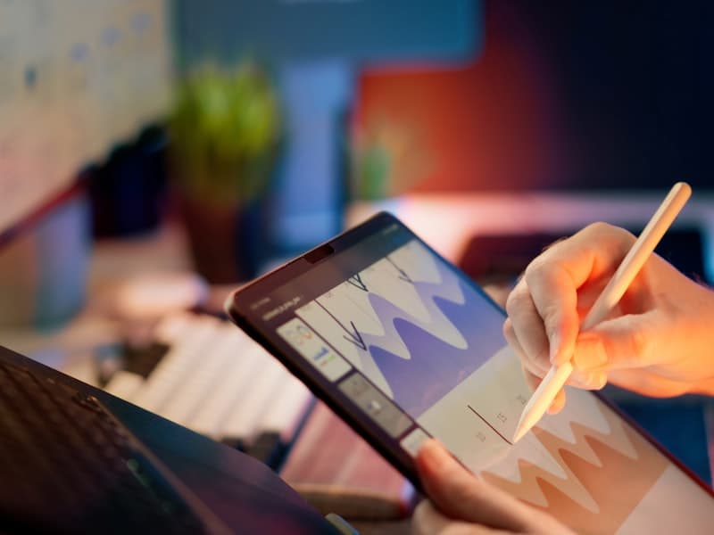 A hand annotating measured results on a tablet