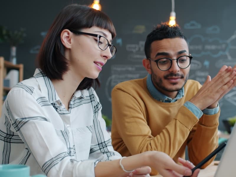 Two colleagues working through something together at one laptop